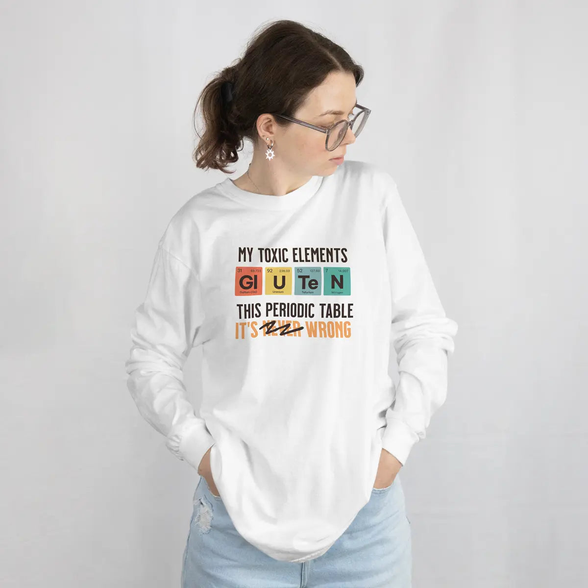 Mujer con una sudadera blanca con el gráfico de la tabla periódica Mis elementos tóxicos, para celiacos