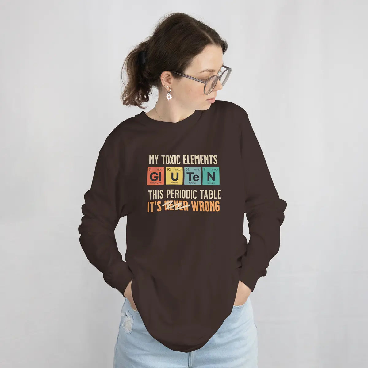 Mujer con una sudadera marrón con el gráfico de la tabla periódica Mis elementos tóxicos, para celiacos